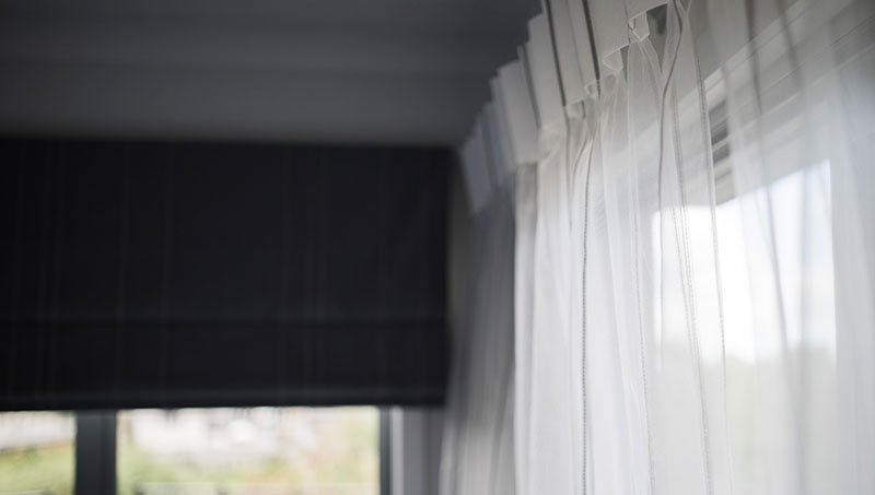 Sheer white drapes and black blind contrast