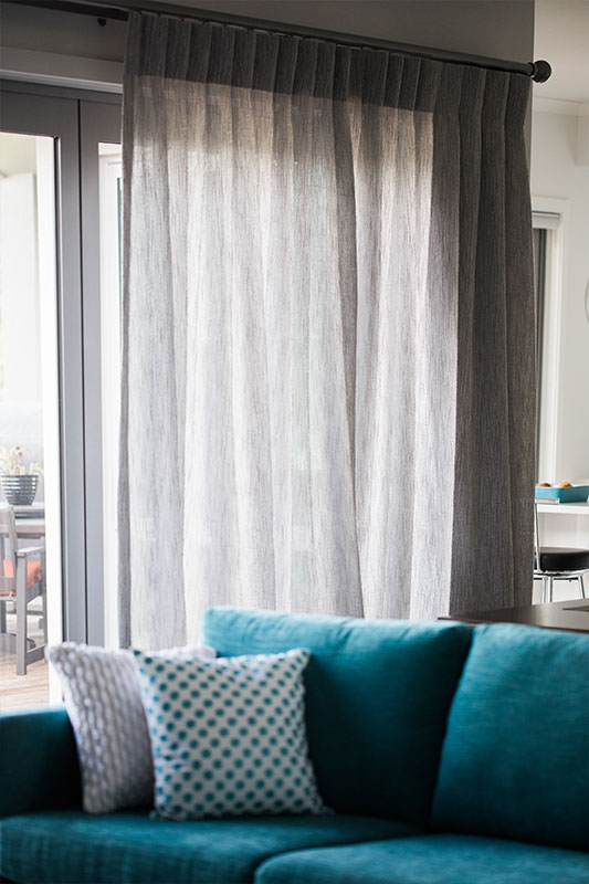 Sheer drapes in lounge with teal couch