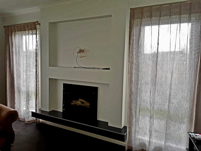 Sheer drapes pulled near fireplace